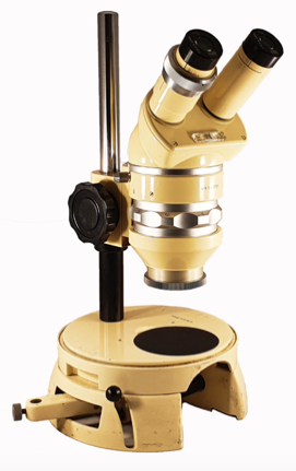 A yellow microscope with a round base
Description automatically generated