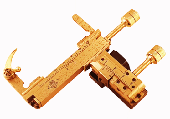 A gold scale with a handle
Description automatically generated